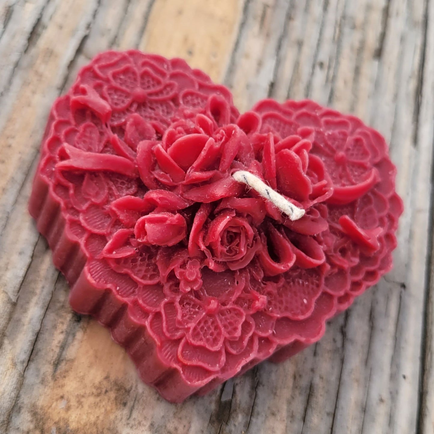 A handmade heart candle with roses in dark red.