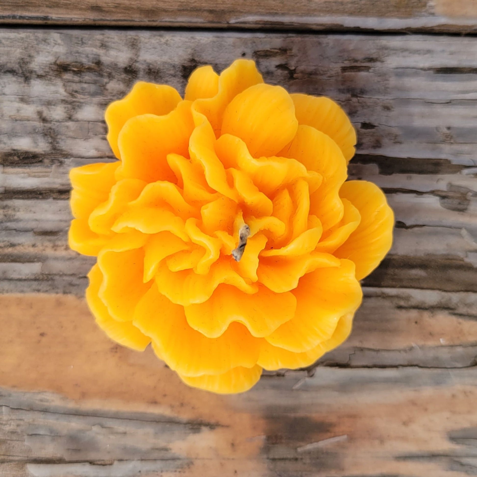 A handmade yellow flower votive candle.