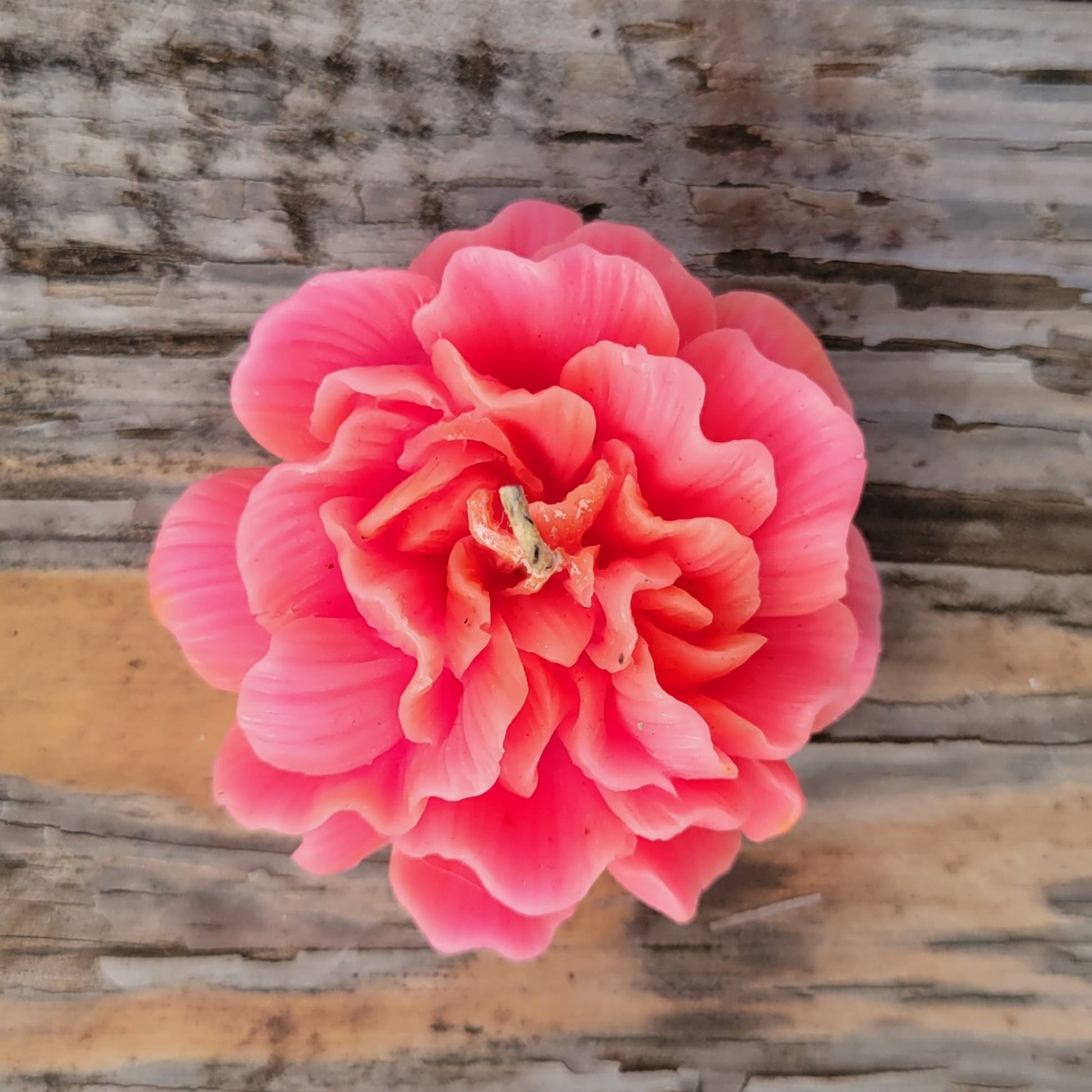 A handmade pink flower votive candle.