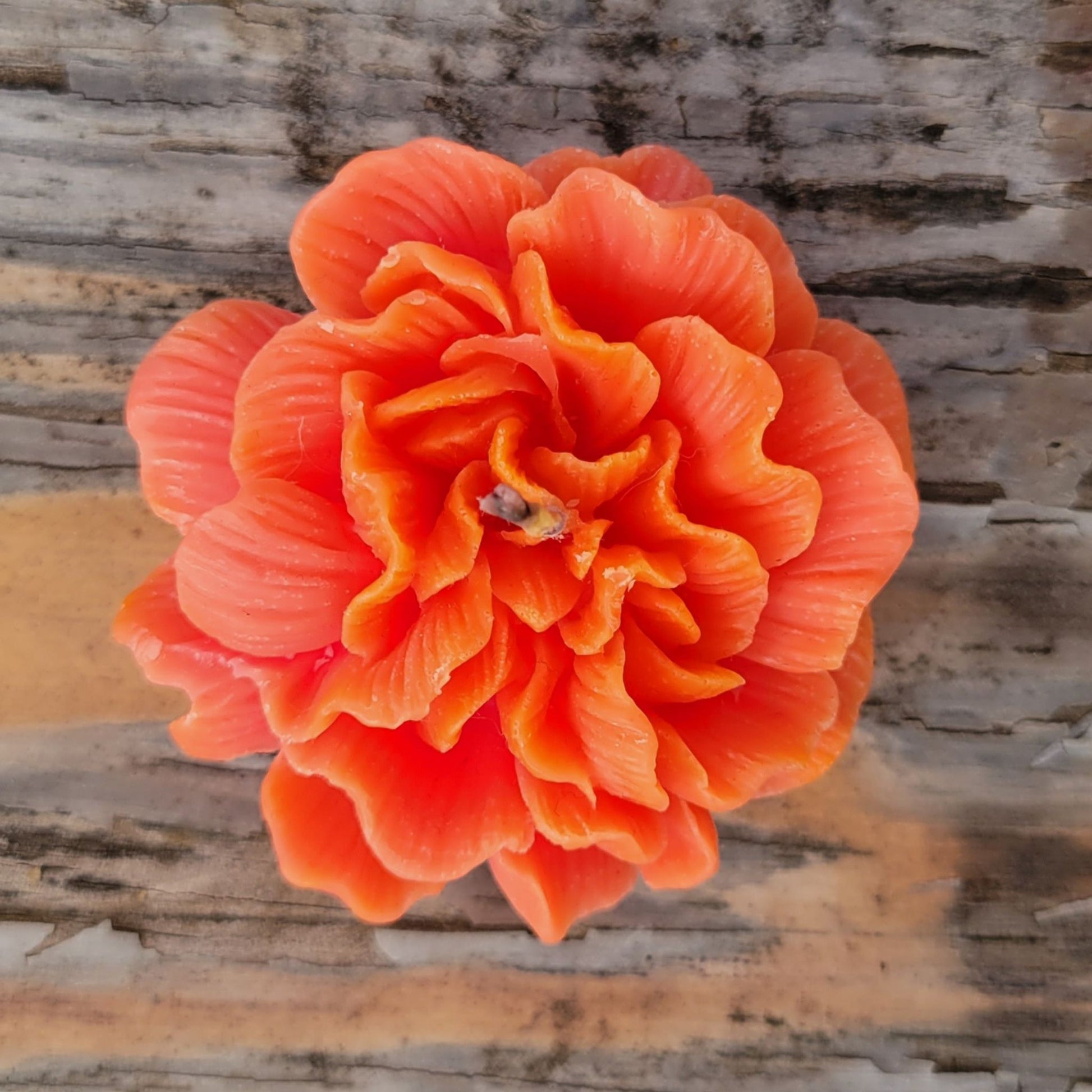 A handmade coral flower votive candle.