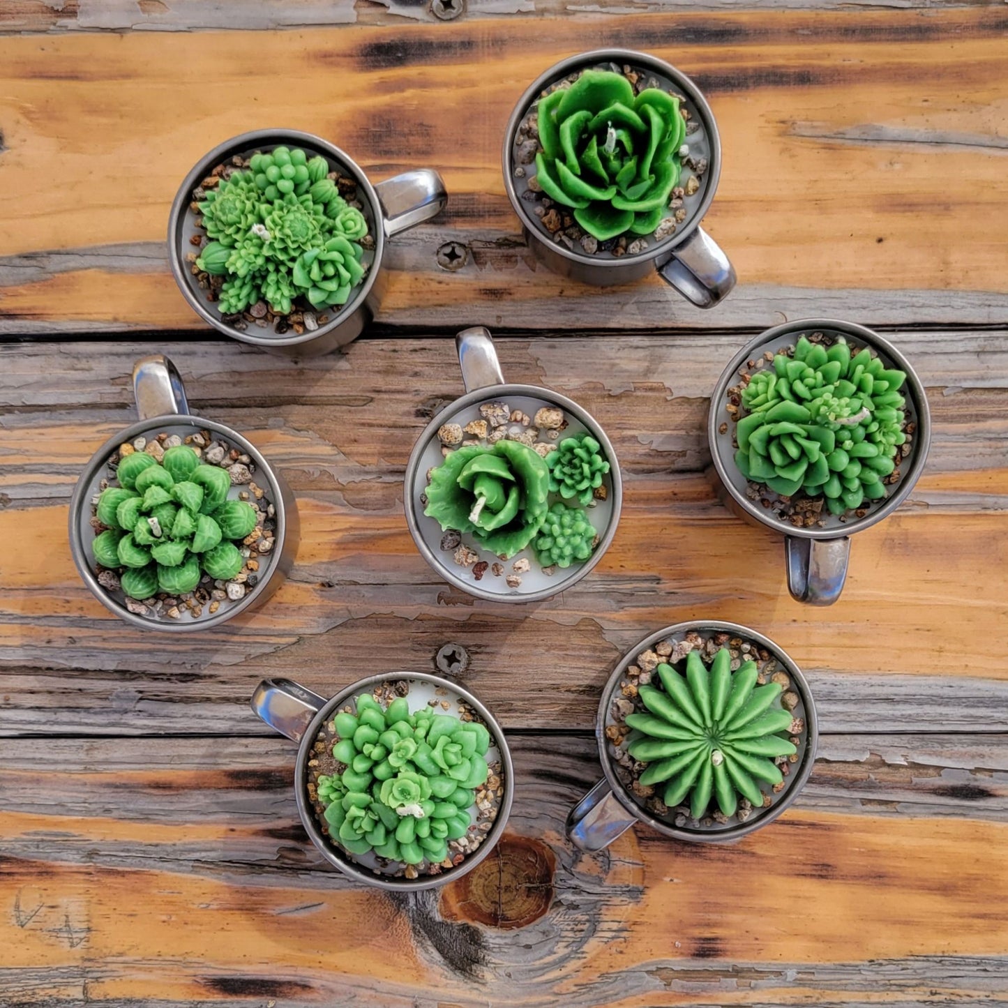 Seven handmade cactus candles in stainless steel mug.