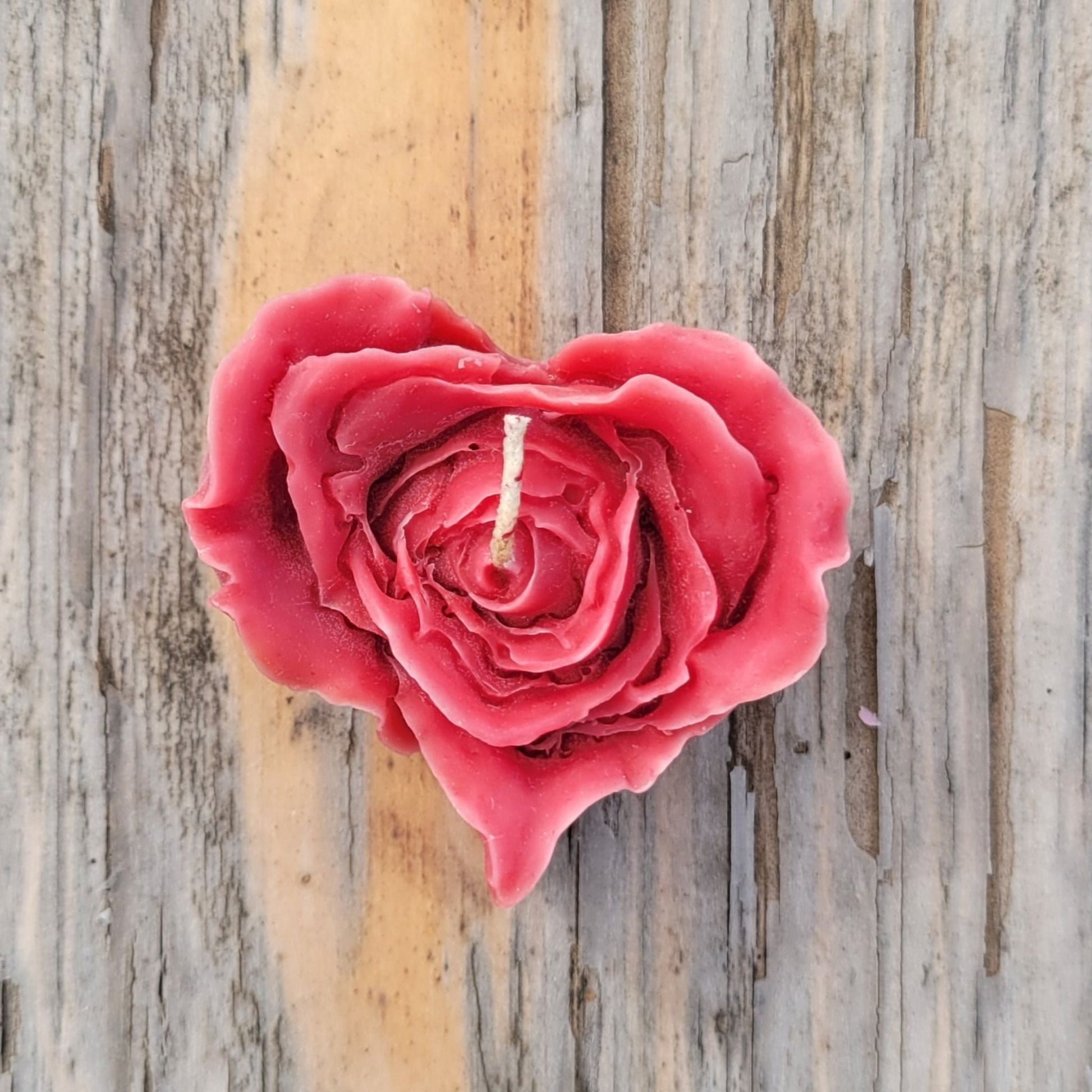 A handmade dark red heart shaped flower votive candle.