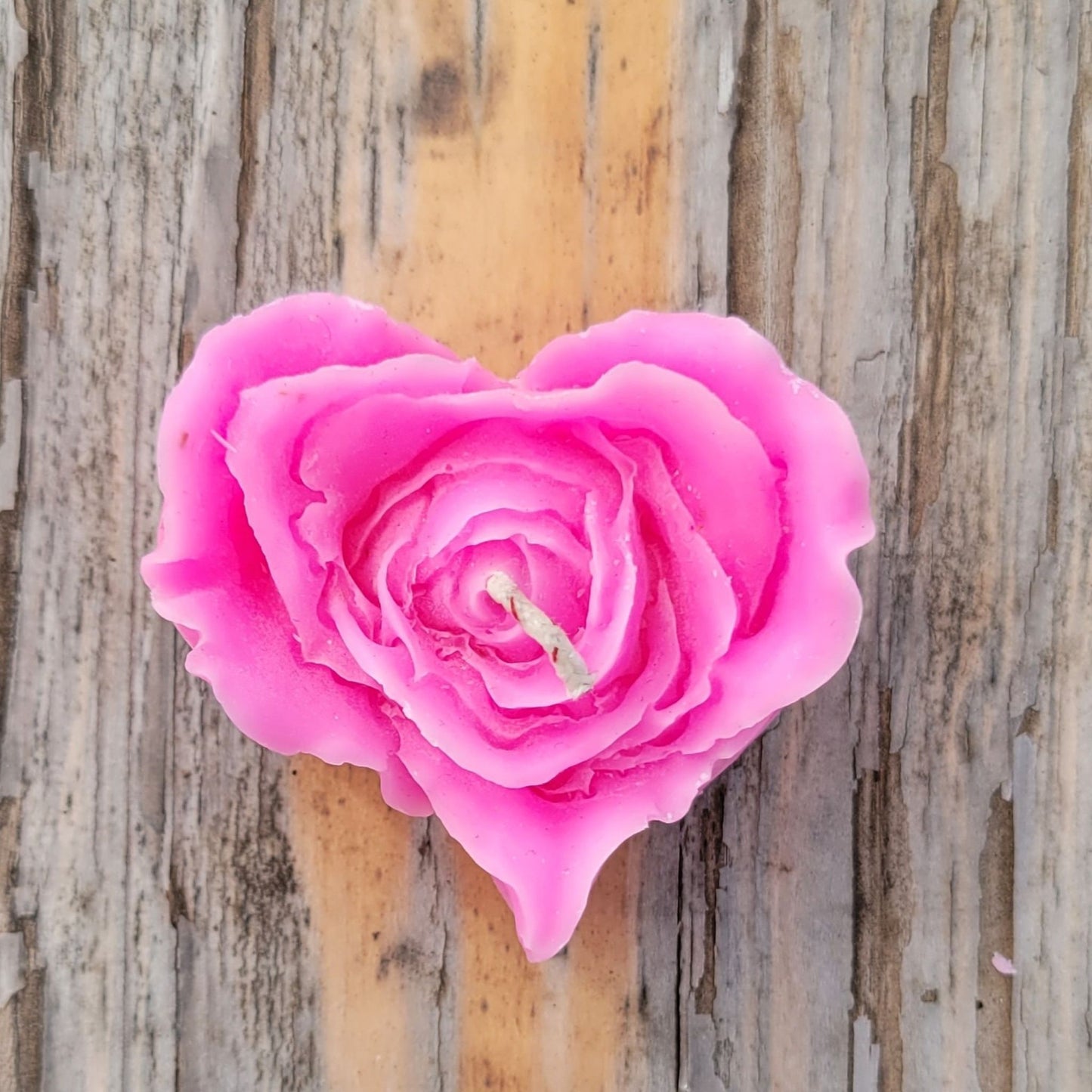 A handmade pink heart shaped flower votive candle.