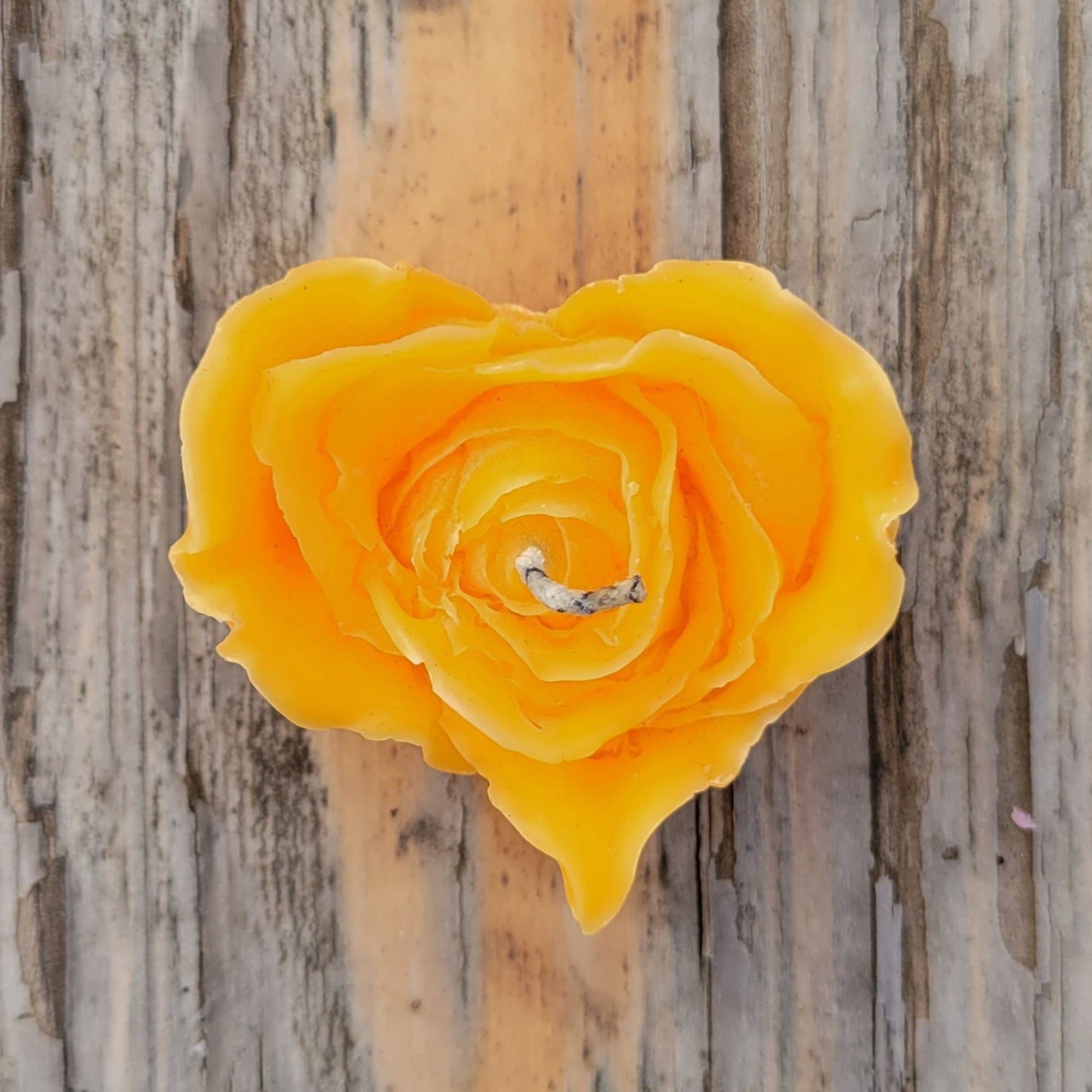 A handmade yellow heart shaped flower votive candle.