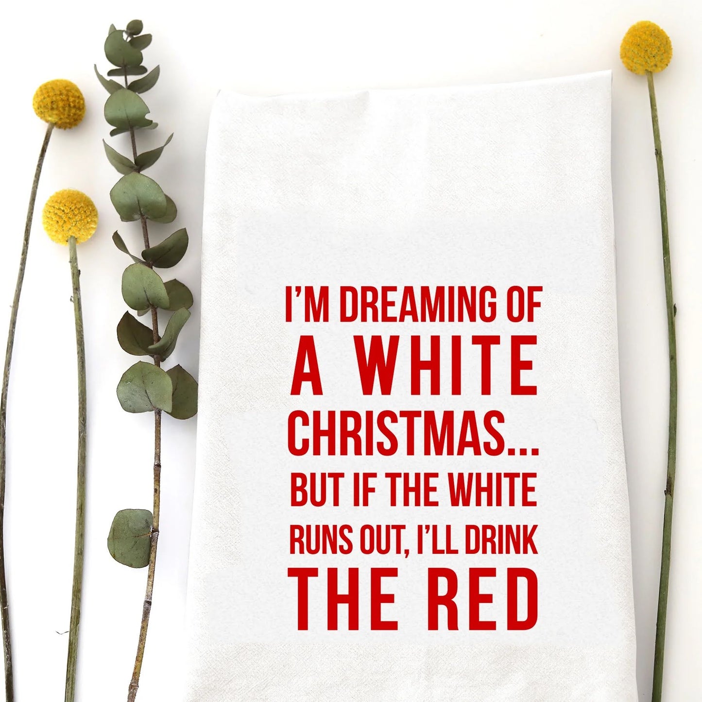 A holiday tea towel with the words "I'm dreaming of a white Christmas... but if the white runs out, I'll drink the red" printed on it.