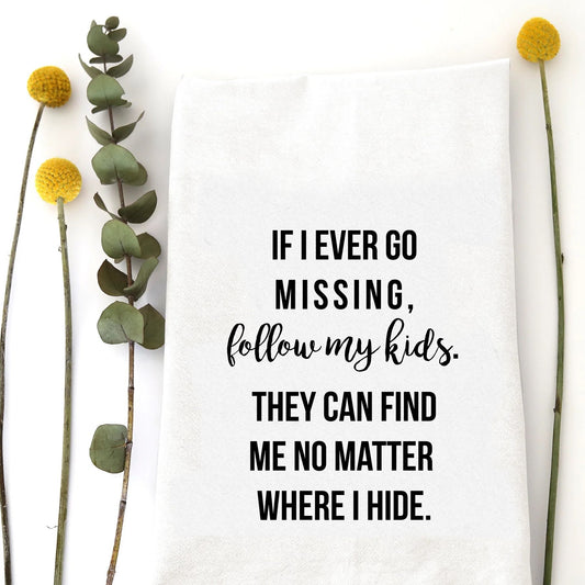 A tea towel with a funny saying - If I ever go missing, follow my kids. They can find me no matter where I hide.