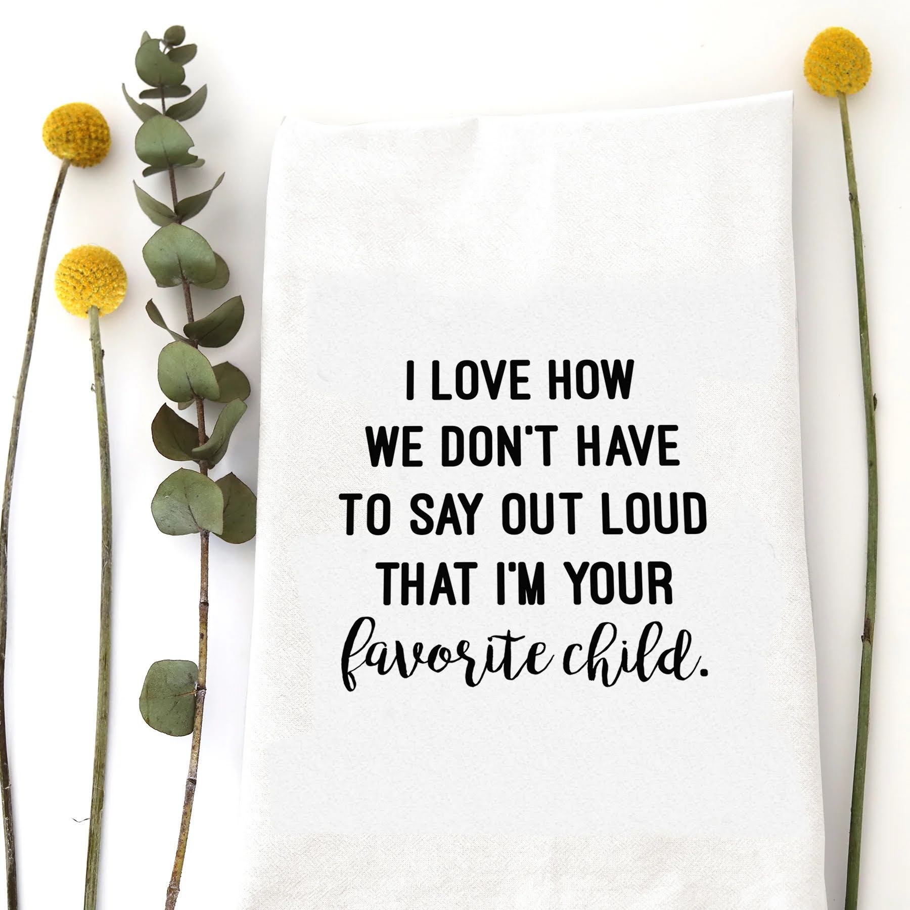 A tea towel with a funny saying - I love how we don't have to say out loud that I'm you favorite child.