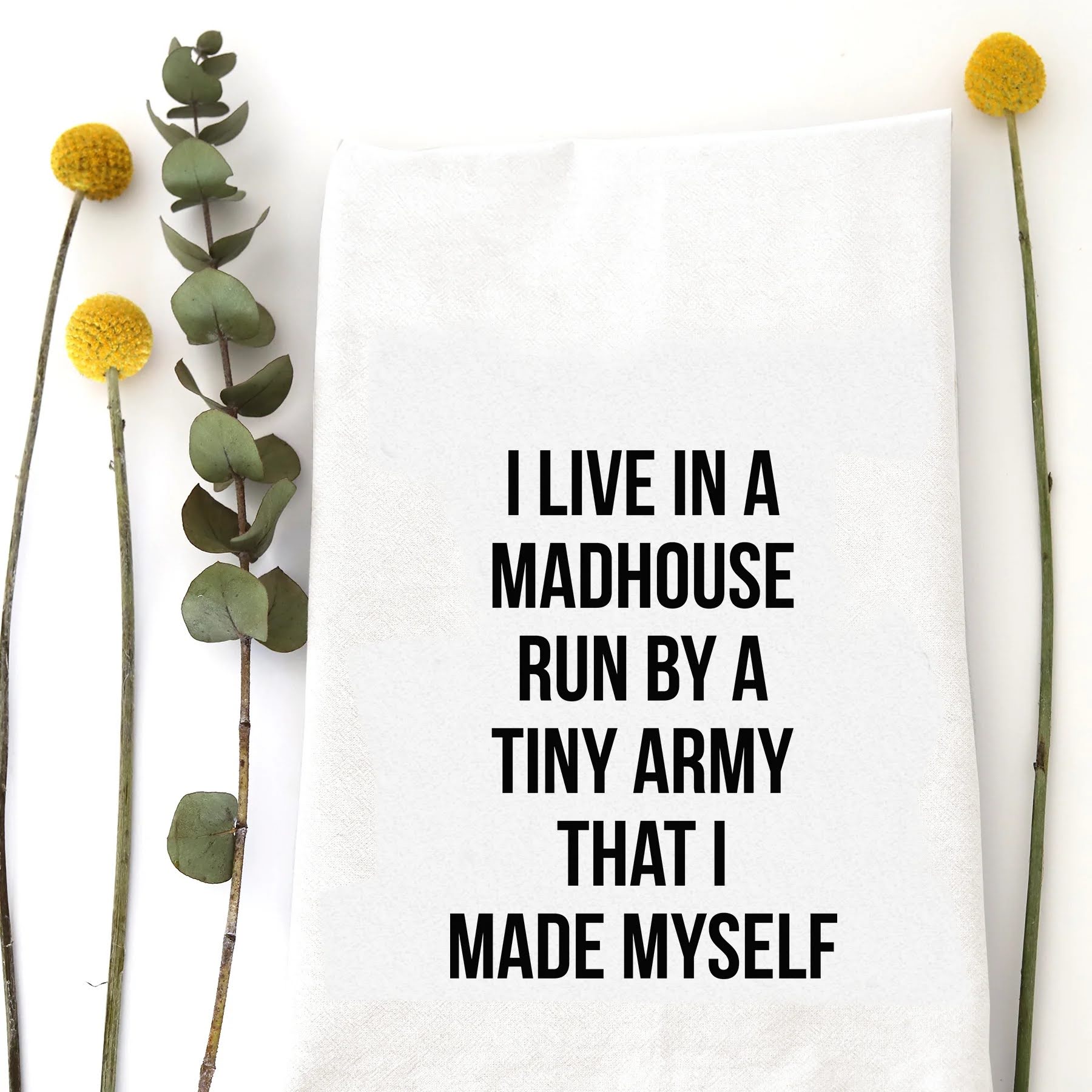 A tea towel with a funny saying - I live in a madhouse run by a tiny army that I made myself.
